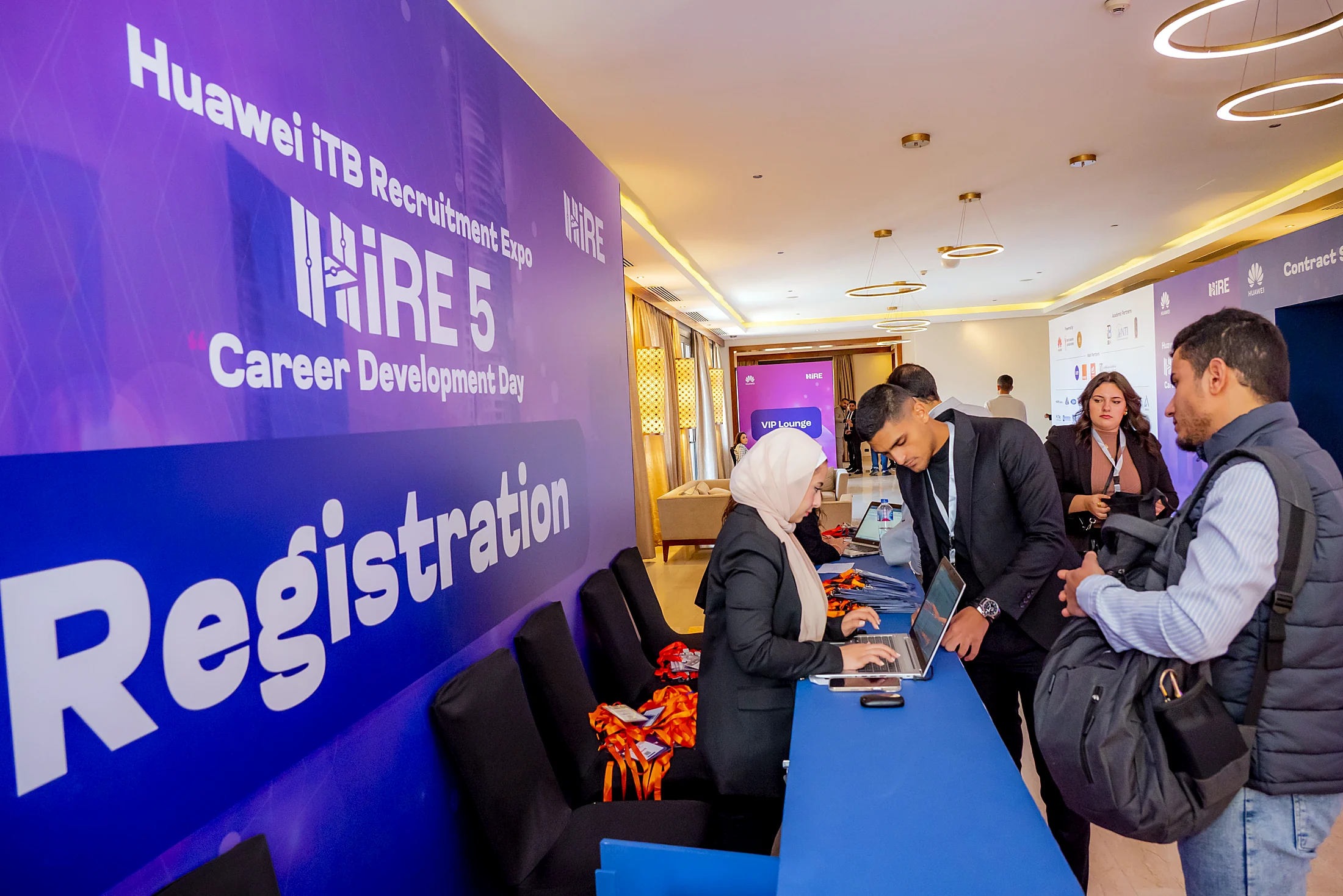 Attendees checking in at the blue HiRE 5 Registration desk
