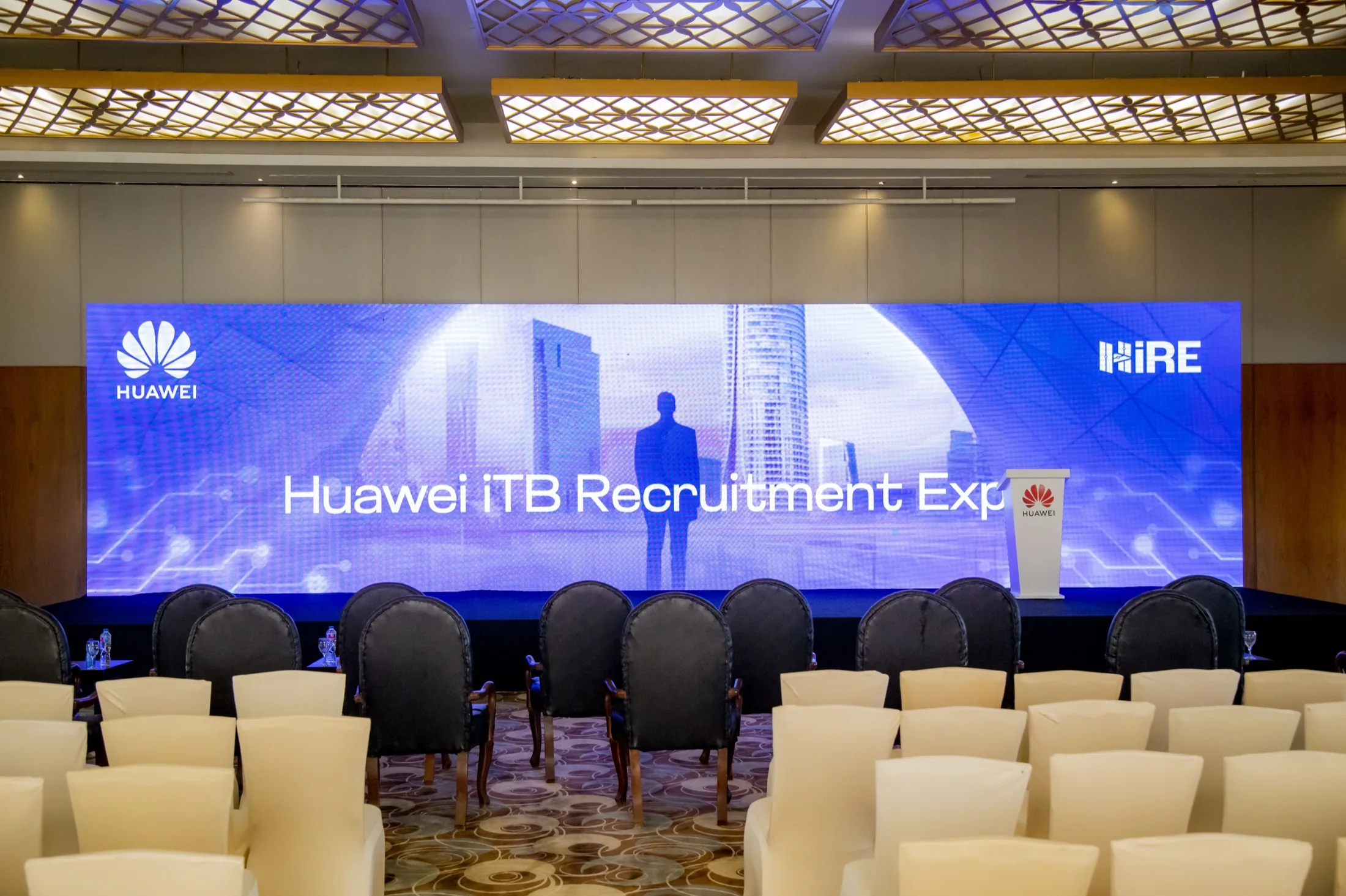 The grand ballroom staged with rows of seating facing the branded LED stage