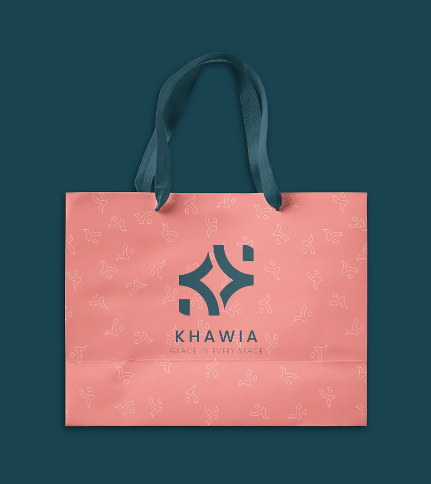 Khawia shopping bag — coral with petrol ribbon handles and the mark, on petrol