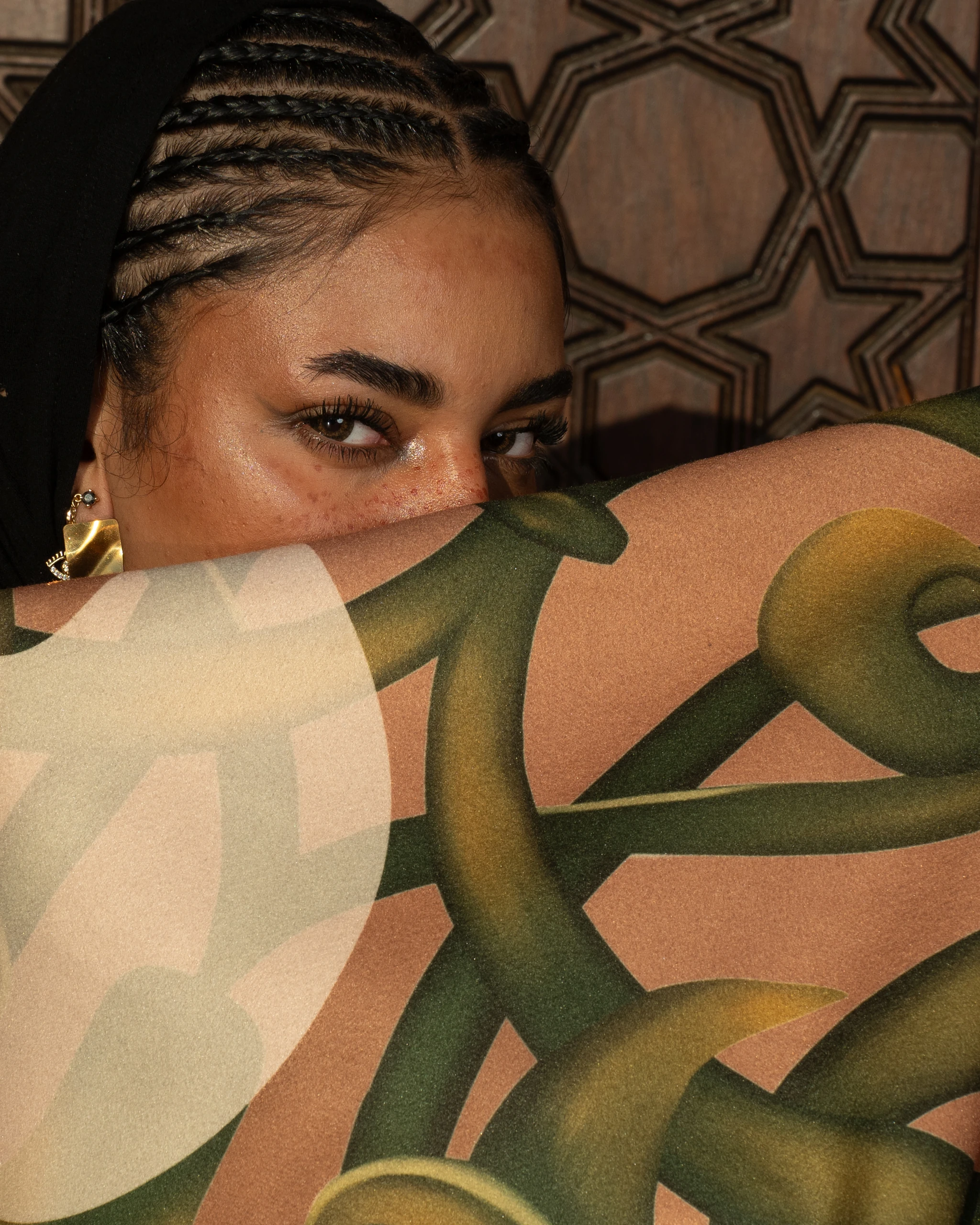 Khawia — a hand and gold cuff on a draped navy sleeve